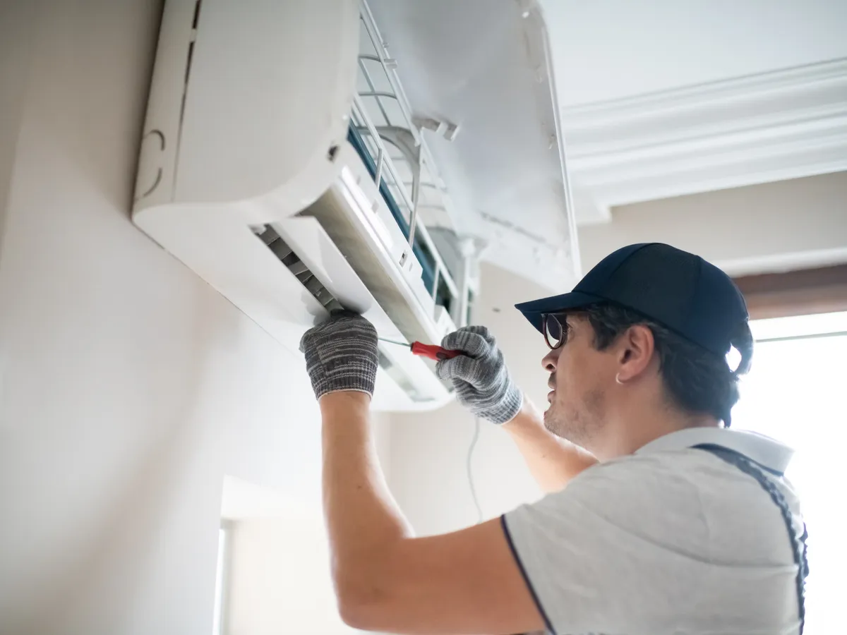 Técnico de TECNIFLASH reparando aire acondicionado